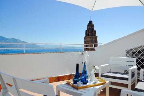 a balcony with a table and chairs and a clock tower at Il Bottone al Duomo in Gaeta