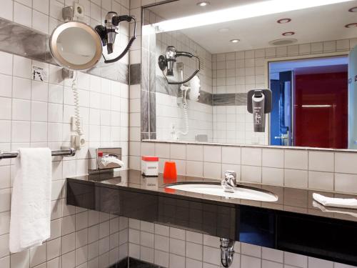 フィリンゲン・シュヴェニンゲンにあるDORMERO Hotel Villingen-Schwenningenのバスルーム(洗面台、鏡付)