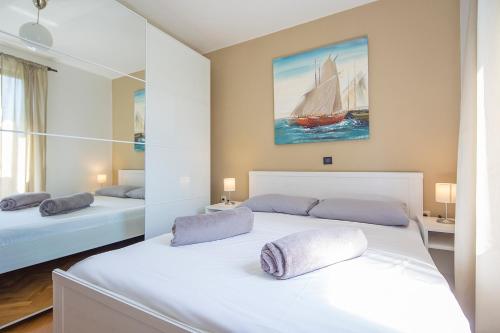 a bedroom with two beds and a sail boat on the wall at Apartments Bo in Malinska