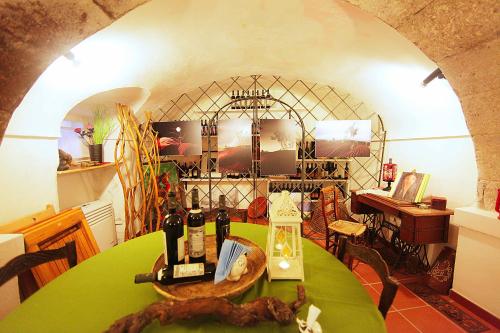 Una habitación con una mesa con botellas de vino. en Aghinas, en Bosa