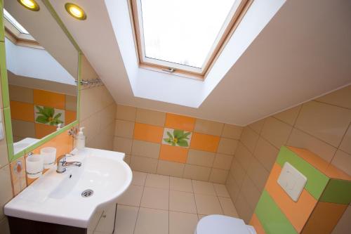 ein Badezimmer mit einem Waschbecken und einem Dachfenster in der Unterkunft Villa Remedios in Łeba