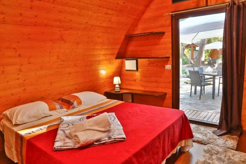 a bedroom with a bed with a red blanket at Campeggio Sanfilippo in Cefalù