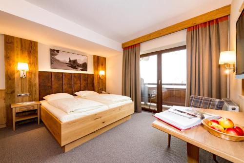 Habitación de hotel con cama y escritorio con un bol de fruta en Gasthaus Hotel Oberwirt, en Ebbs