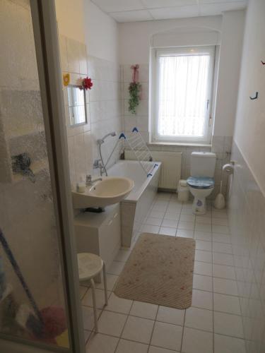 ein Badezimmer mit einer Badewanne, einem Waschbecken und einem WC in der Unterkunft Ferienwohnung Zahn in Oelsnitz