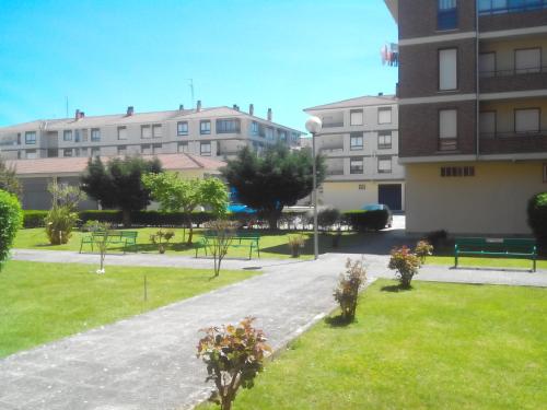 a park in front of a building with benches and grass at Vivienda uso turistico El Vie in Villarcayo