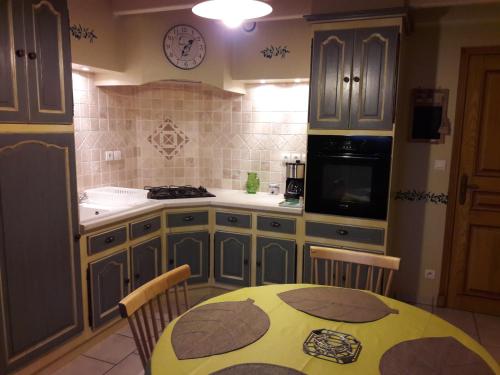 a kitchen with a table and a clock on the wall at gite la Pinetterie in Civray-de-Touraine