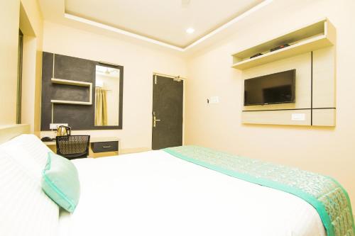 a hotel room with a bed and a tv at KK Inn in Gūduvāncheri