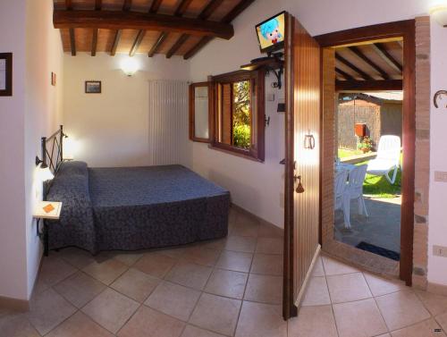 a bedroom with a bed and a sliding glass door at La Merla in Castiglione della Pescaia