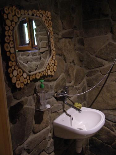 a stone bathroom with a sink and a mirror at To Lem Ande in Lumshory