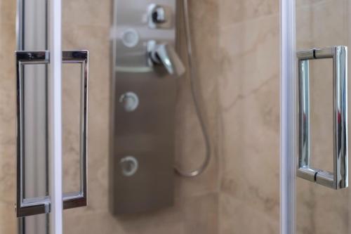een douche in een badkamer met een glazen deur bij Palazzo Della Mura in Angri