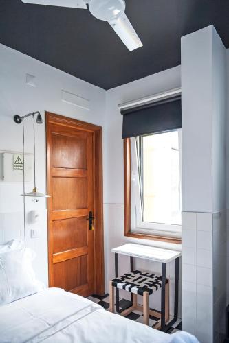 a bedroom with a bed and a table and a window at Lemon Tree Stay in Faro