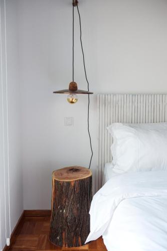 a tree stump side table next to a bed at Lemon Tree Stay in Faro
