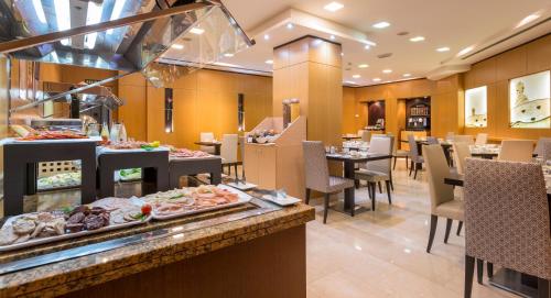 a restaurant with a buffet of food on a table at Eurostars Monumental in Barcelona