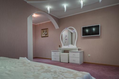 a bedroom with a bed and a mirror and a tv at Vele Rosse Hotel, business & leisure in Odesa