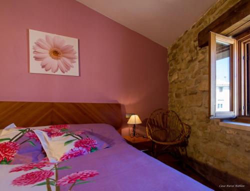 Carcastillo的住宿－Casa Roblan，一间卧室,床上放着鲜花