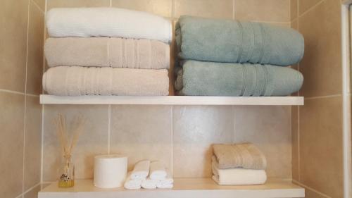 a pile of towels on a shelf in a bathroom at Mossel 11 Studio in Bloubergstrand