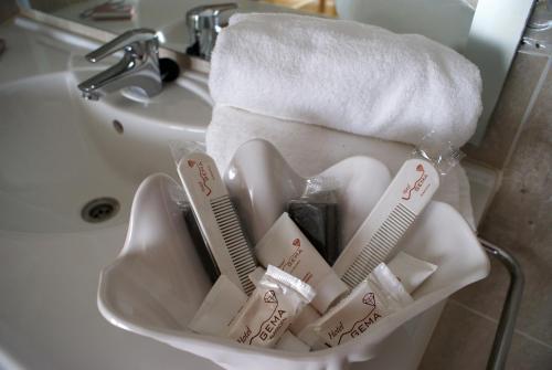 a basket of toothbrushes and towels in a sink at Hotel Gema in Almadén