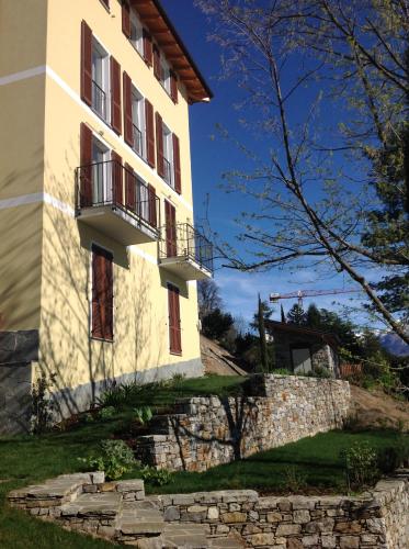 a building with a stone wall and a balcony at Lakefront Villa Del Pierangelo in Cremia