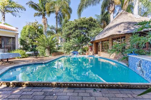 a swimming pool in front of a house at Bay Tree Guest House in Pretoria