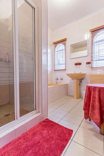 a bathroom with a shower and a sink at Bay Tree Guest House in Pretoria