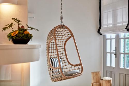 a hanging rattan chair hanging from a wall at Mr and Mrs White Paros in Naousa