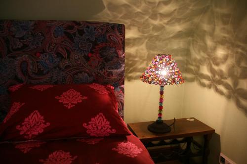 a lamp sitting on a table next to a bed at Peahen Residence in Sigulda