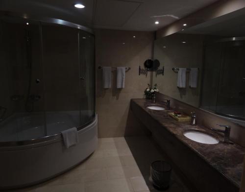 a bathroom with two sinks and a large mirror at Best Inn Erbil in Erbil