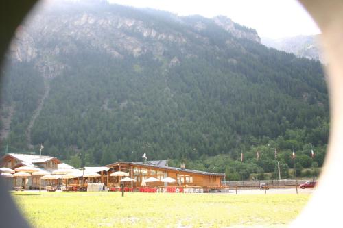 a building with umbrellas in front of a mountain at Hotel La Pigna in Bardonecchia