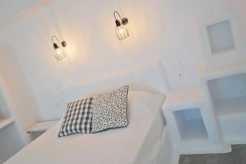 a white couch with a pillow on it with lights at Annio studios in Plaka