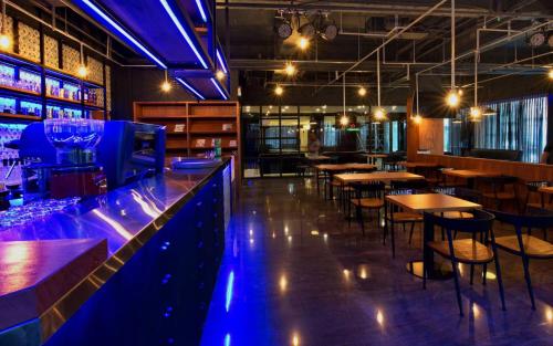 a bar with tables and chairs and blue lighting at Fulidun Hotel Kenting in Hengchun