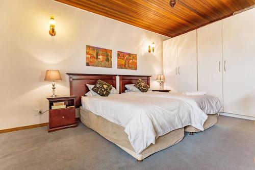 a bedroom with a large bed and a wooden ceiling at Bay Tree Guest House in Pretoria