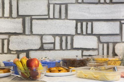 una tavola ricoperta di ciotole di frutta e altri alimenti di Louiza Hotel a Paroikia