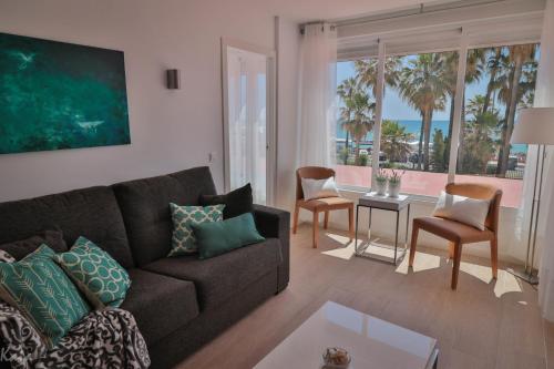 a living room with a couch and a table with chairs at Piso Paseo Marítimo in Benalmádena