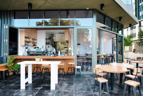 a restaurant with tables and chairs and windows at Opera Apartments South Brisbane in Brisbane