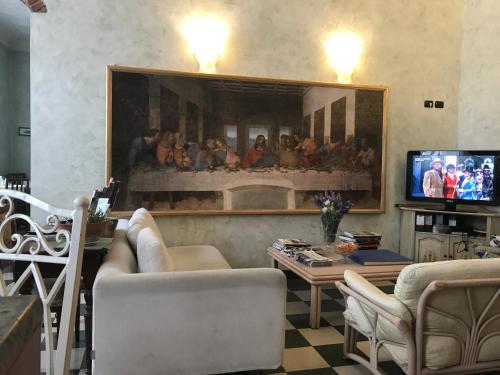 a living room with a large painting on the wall at Hotel Giglio in Florence
