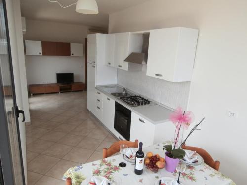 una cucina con tavolo, tovaglia e sidro da tavolo di Donizetti Apartment 1 a Roseto degli Abruzzi