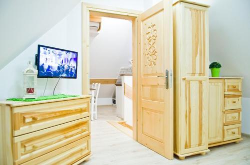 uma porta de madeira aberta num quarto com uma televisão em Willa Galówka em Szaflary