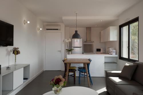 een keuken en een woonkamer met een bank en een tafel bij Résidence Hôtelière Alcyon in Porto-Vecchio