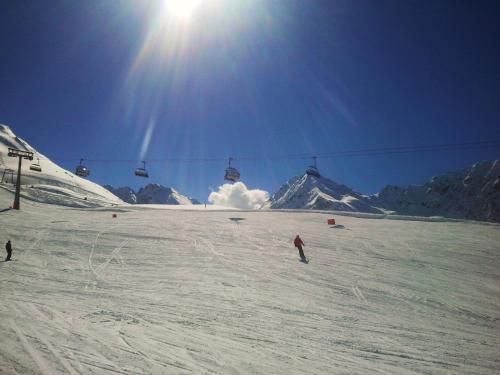 a person skiing down a snow covered slope with a ski lift at Ledererhof Apartments in Sankt Jakob in Defereggen