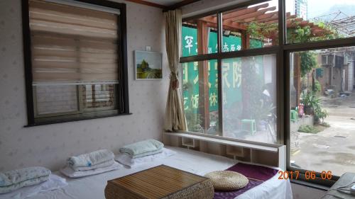 Habitación con 2 camas y ventana grande. en Huangyaguan Great Wall Li Bo Home Hotel, en Jixian