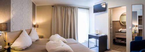 a hotel room with a bed with white pillows at Pension Julia & Haus Elisabeth - Wallner's Hofheuriger & Weinhof in Mörbisch am See