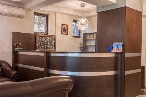 a bar in a restaurant with a leather chair at Prestige Hotel in Belene