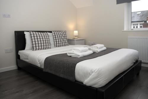 1 dormitorio con 1 cama grande y toallas. en Guest House London, en Londres