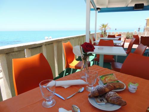海濱西庫利亞納的住宿－Hotel Residence Paguro，一张带食物的桌子,享有海景