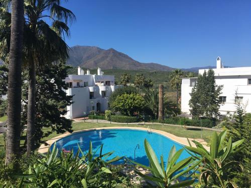 a swimming pool in front of a building at Estepona Golf - Los Pintores in Estepona