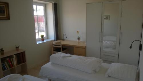 a bedroom with a bed and a desk and a window at Moselundgaard B/B og Hestehotel in Engesvang