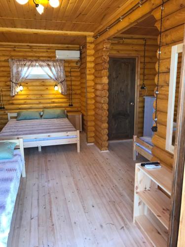 Habitación con cama en una cabaña de madera en Guest House Semeyniy en Peresyp