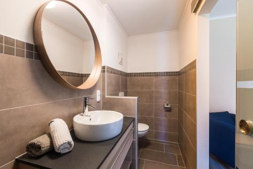 a bathroom with a sink and a mirror at Pension Julia & Haus Elisabeth - Wallner's Hofheuriger & Weinhof in Mörbisch am See