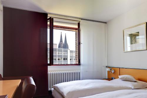 sypialnia z 2 łóżkami i oknem w obiekcie Maternushaus w Kolonii