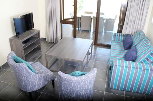 a living room with a couch and chairs and a table at Bilene Lodge by Dream Resorts in Vila Praia Do Bilene